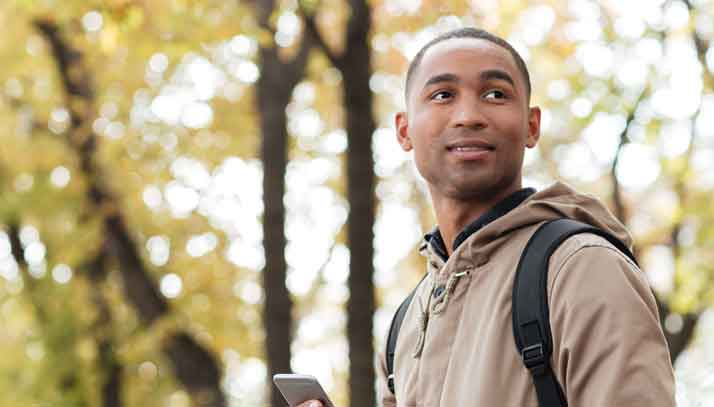 Young man walking in a park looking to the distance