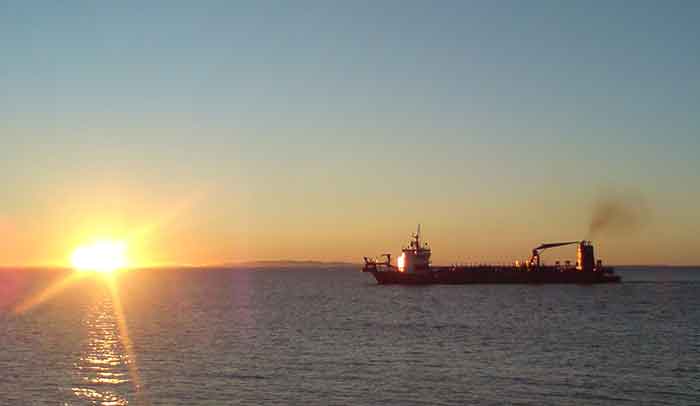 Comercial ship on the water at sunset